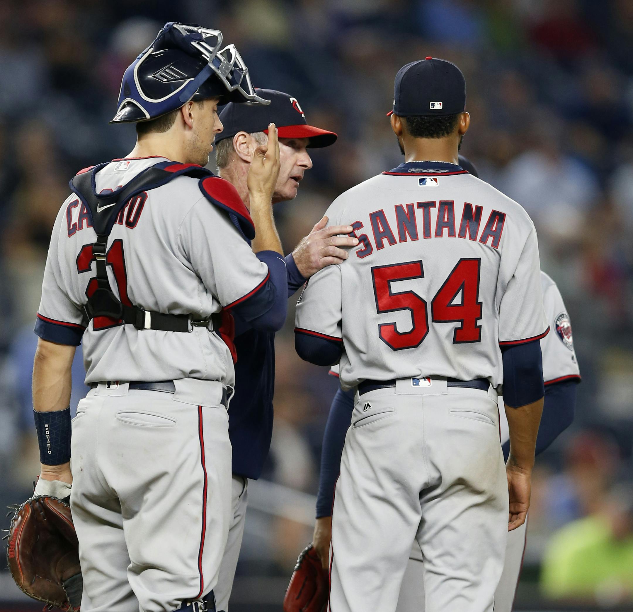 Minnesota Twins catcher Jason Castro, left, watches as manager Paul Molitor, second from left, checks on Twins starting pitcher Ervin Santana (54) before removing Santana in the sixth inning of a baseball game against the New York Yankees in New York, Monday, Sept. 18, 2017. (AP Photo/Kathy Willens)