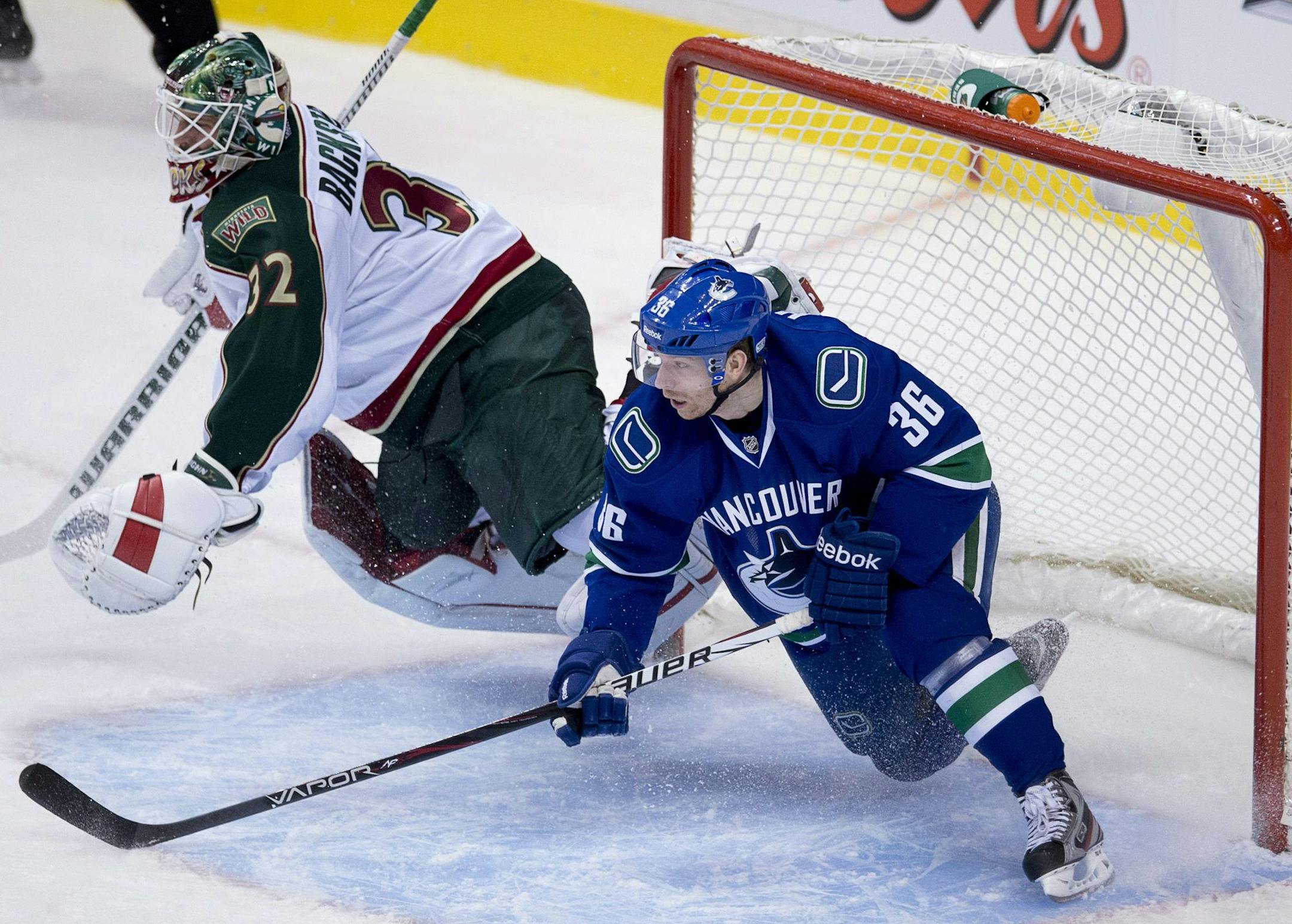 Vancouver Canucks right wing Jannik Hansen (36) crashes into the net as Minnesota Wild goalie Niklas Backstrom (32) looks on during second period NHL hockey action at Rogers Arena in Vancouver, British Columbia Monday, March,18, 2013. (AP Photo/The Canadian Press, Jonathan Hayward)