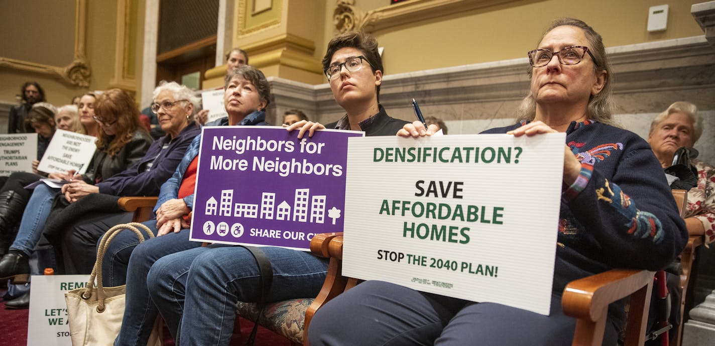 Nancy Przymus, from right, holds a sign against the 2040 Comprehensive Plan, as her neighbor Blue Delliquanti holds a sign supporting the plan during the meeting. ] LEILA NAVIDI &#xef; leila.navidi@startribune.com BACKGROUND INFORMATION: The City of Minneapolis 2040 Comprehensive Plan update and time for public comment is given during the Minneapolis City Planning Commission meeting at Minneapolis City Hall on Monday, October 29, 2018.