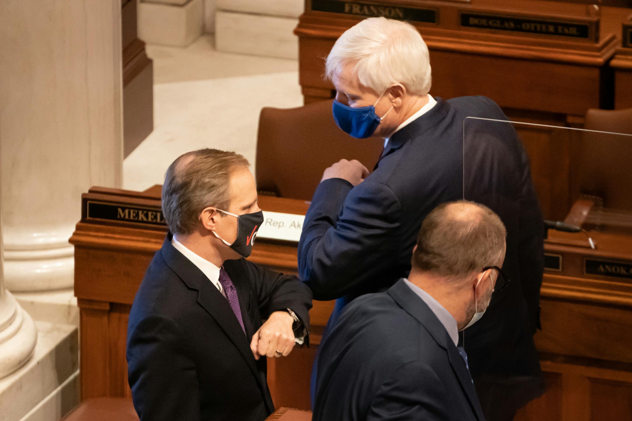 Secretary of State Steve Simon and State Supreme Court Associate Justice Paul Thissen elbow bumped on the House Floor before the swearing in ceremony.  Thissen performed the swearing in ceremony.
