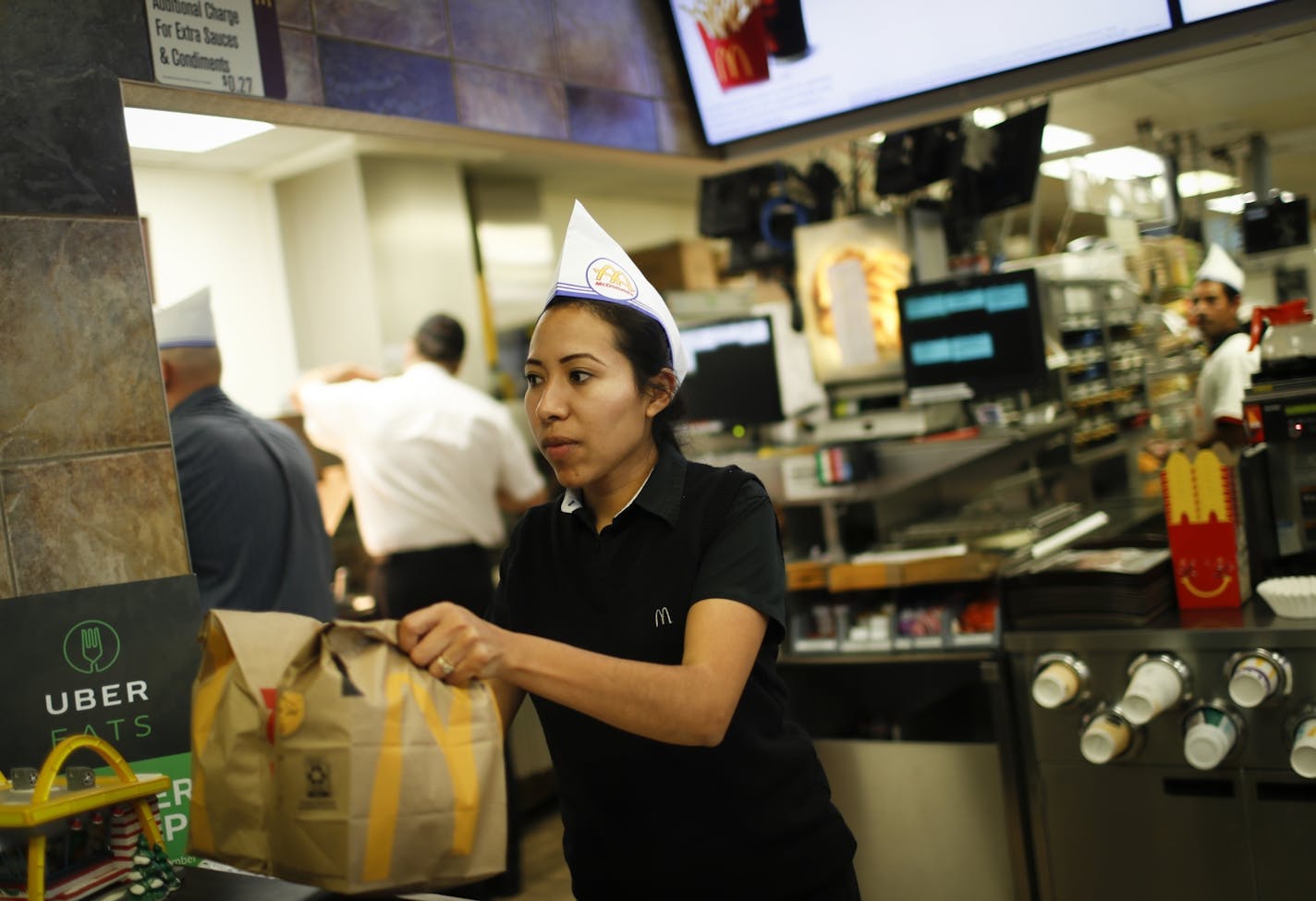 Lorena Sanchez served an order to go as the Roseville McDonald's celebrated 60 years of business with 60-cent hamburgers and wearing throwback uniforms on Monday.