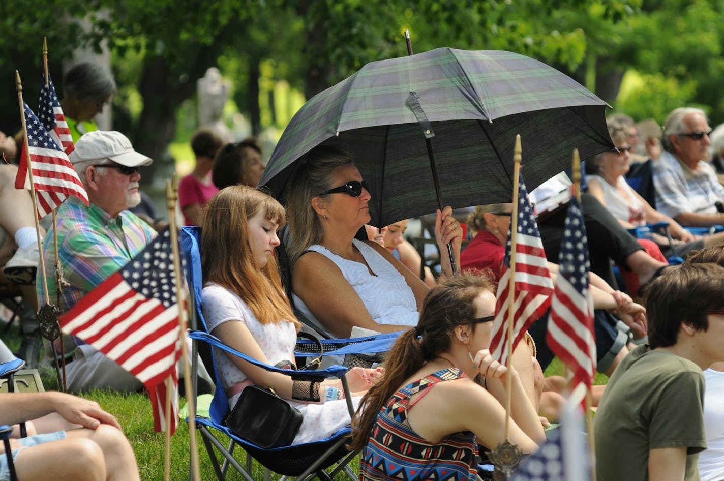 A Memorial Day service was held in Minneapolis at Lakewood Cemetery near the Soldiers Memorial monument on Monday morning May 28,2012. Melanie Hall of Minneapolis stayed cool under an umbrella with her 17 year old daughter Maura Hall-Ford by her side during the Memorial day service.