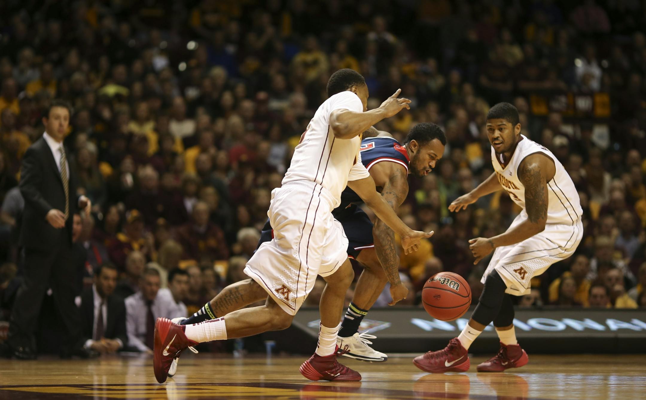 Gophers guard Daquein McNeil (5) stripped the ball from St. Mary's Gaels guard Paul McCoy (2) in the second half. Gophers guard Maverick Ahanmisi (13) was at right.