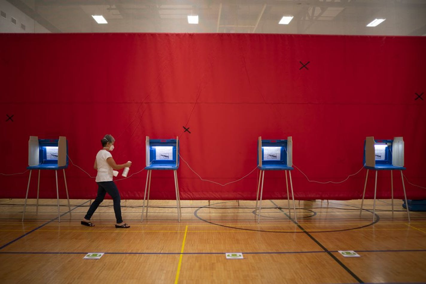 Voting judge Johanna Boller cleaned the voting booths after used in the gymnasium at Highland Park Middle School where Ward 3, Precinct 14 voters cast their votes in the primary election.