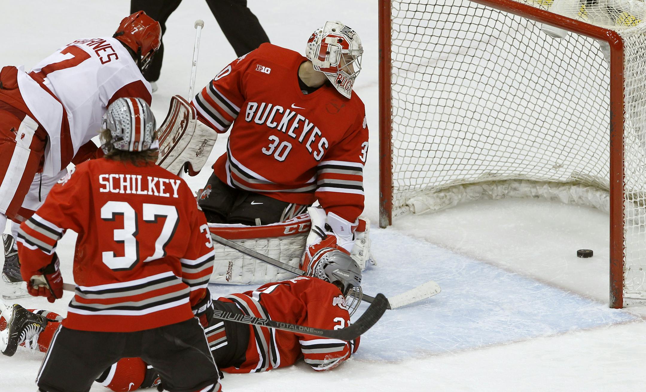 Ohio State goalie Christian Frey (30), defenseman Sam Jardine (21), forward Nick Schilkey (37) and Wisconsin forward Tyler Barnes (7) look at the game-winning shot by Wisconsin forward Mark Zengerle during overtime of the championship college hockey game of the Big 10 Conference tournament in St. Paul, Minn., Saturday, March 22, 2014. Wisconsin won 5-4. (AP Photo/Ann Heisenfelt)
