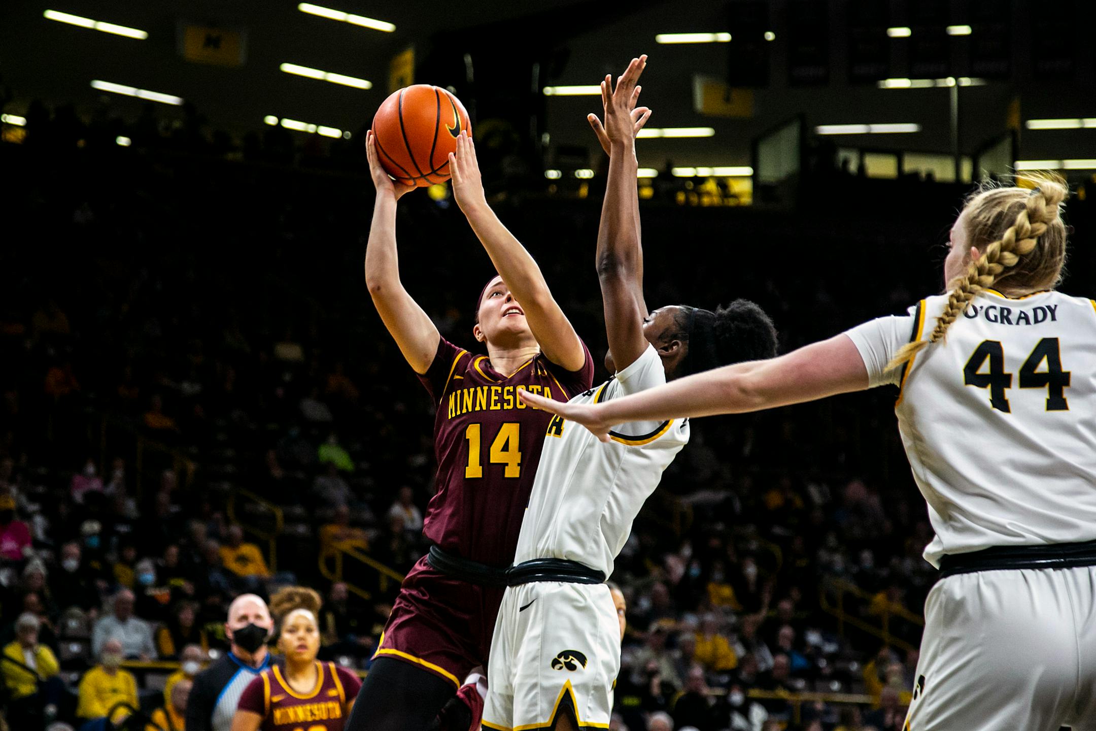 Minnesota guard Sara Scalia shoots a basket as Iowa guards Tomi Taiwo, center, and Addison O'Grady (44) defend during Wednesday's game.
