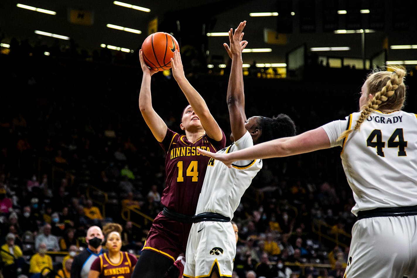 Minnesota guard Sara Scalia shoots a basket as Iowa guards Tomi Taiwo, center, and Addison O'Grady (44) defend during Wednesday's game.