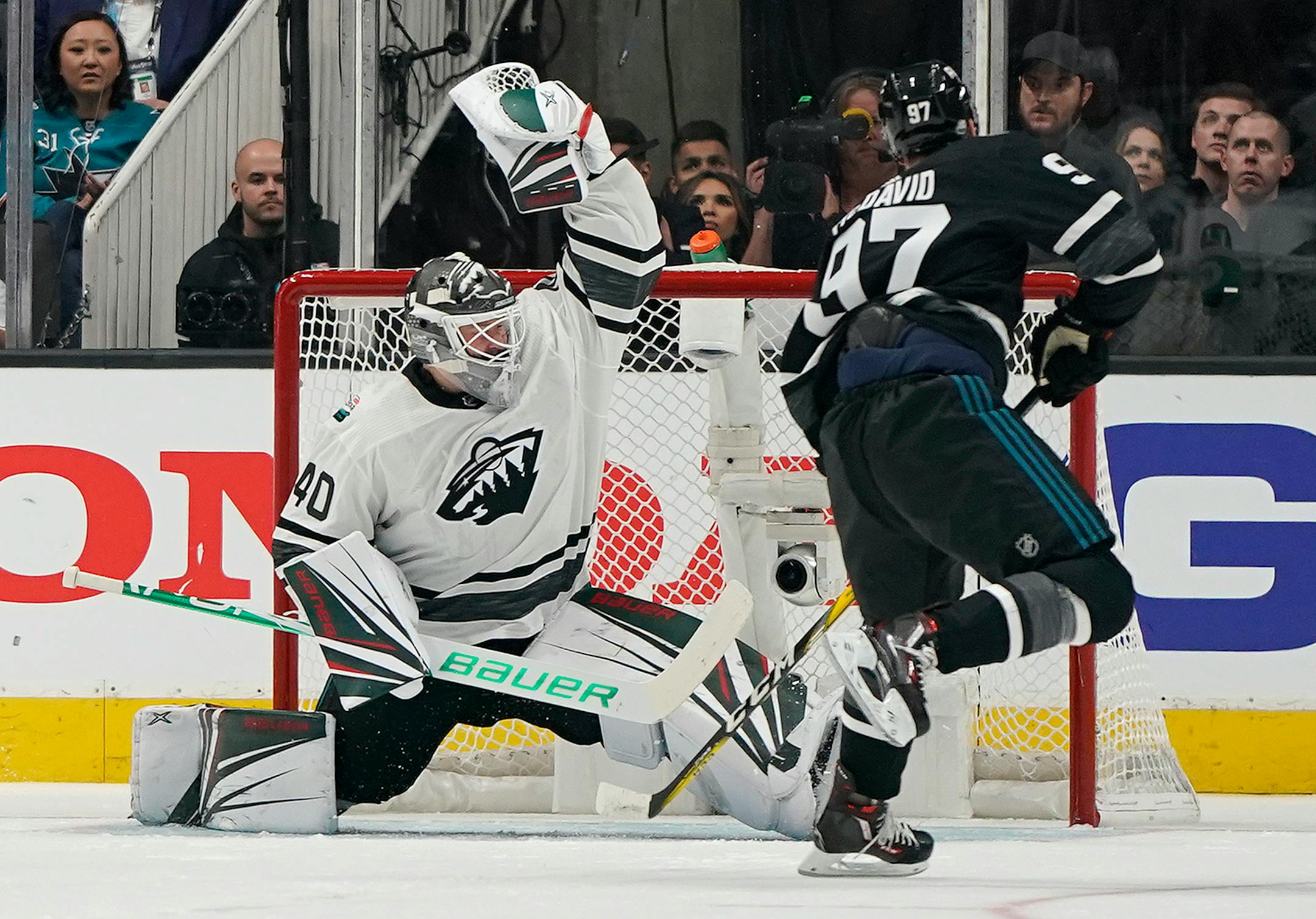 Central Division's Devan Dubnyk, left, of the Wild, defends the net against Pacific Division's Connor McDavid, of the Edmonton Oilers.