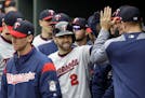 Brian Dozier high-fives teammates in the dugout after scoring on an RBI double by Kennys Vargas in the first inning against the Baltimore Orioles on W