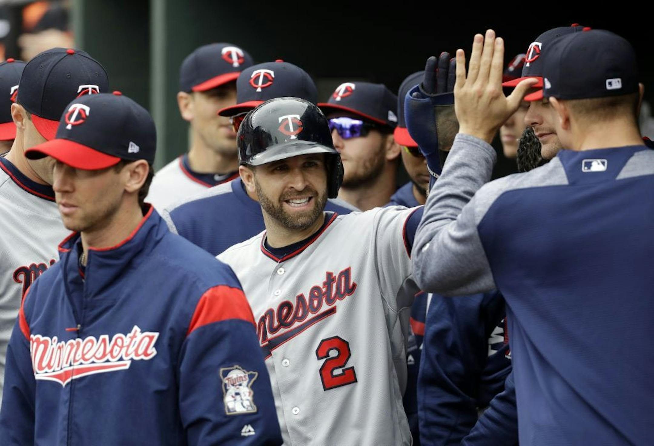 Brian Dozier high-fives teammates in the dugout after scoring on an RBI double by Kennys Vargas in the first inning against the Baltimore Orioles on Wednesday. The Twins swept the series.
