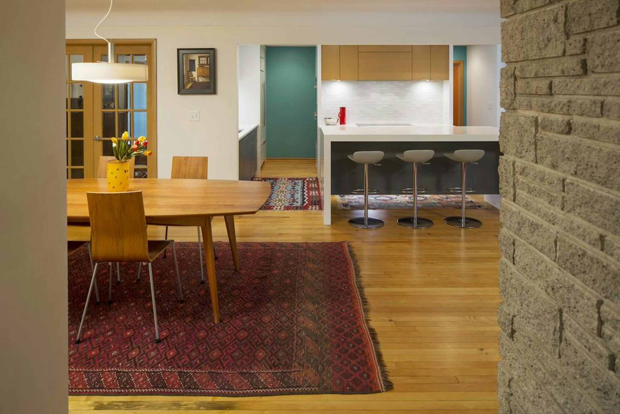 AFTER The family-friendly kitchen living and dining areas flow together and blend with the home's original midcentury modern vibe.