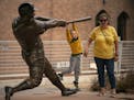 Zach Zimmerman, 5, hung on the bat of the Harmon Killebrew statue for a photo while his mom, Nikki Zimmerman stood nearby before the game against the 