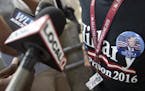 A supporter of Republican presidential candidate Donald Trump is interviewed by local media as he wears a "Hillary for Prison 2016" shirt before the a