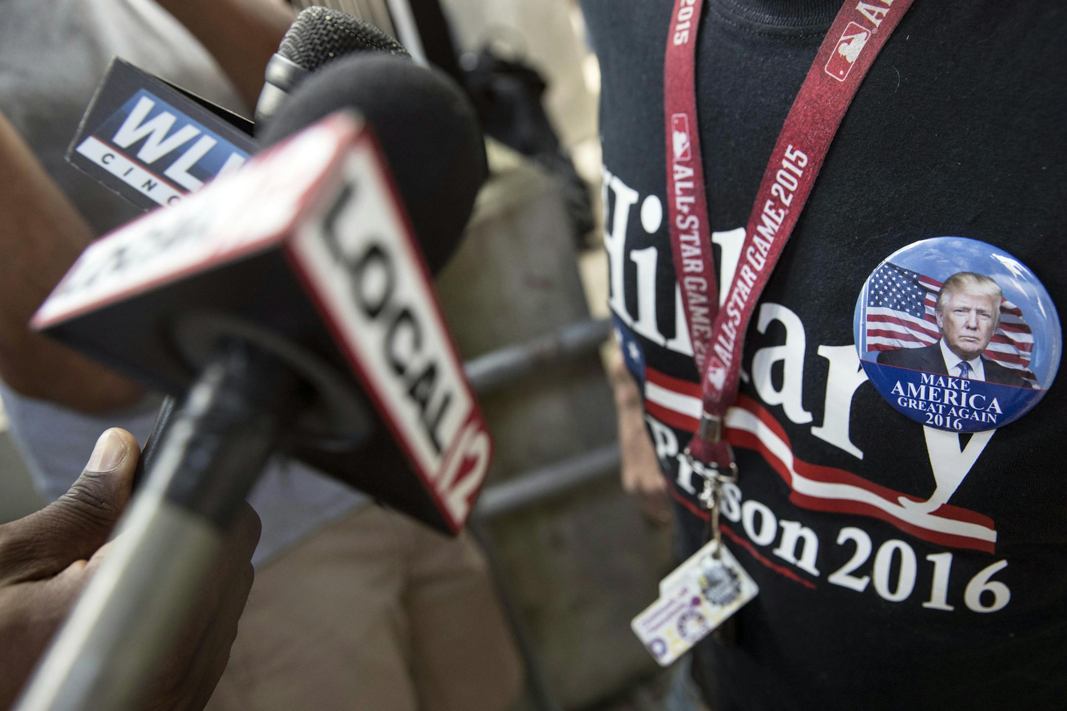 A supporter of Republican presidential candidate Donald Trump is interviewed by local media as he wears a "Hillary for Prison 2016" shirt before the arrival of Trump's vice presidential candidate, Indiana Gov. Mike Pence, ahead of a campaign stop at Price Hill Chili, Saturday, Aug. 6, 2016, in Cincinnati. (AP Photo/John Minchillo)