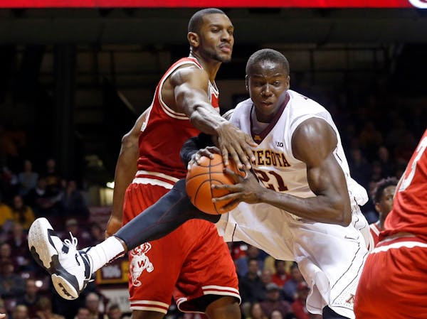 Wisconsin's Vitto Brown, left, tries to get the ball away from Minnesota's Bakary Konate of Mali in the second half of an NCAA college basketball game