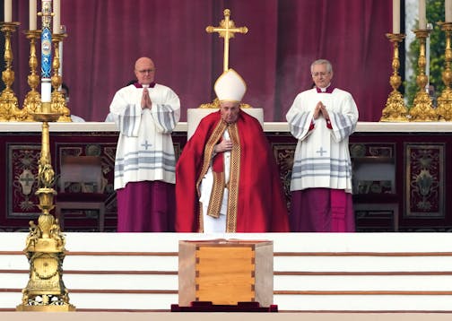 Pope Francis, centre, sits by the coffin of late Pope Emeritus Benedict XVI St. Peter's Square during a funeral mass at the Vatican, Thursday, Jan. 5, 2023.
