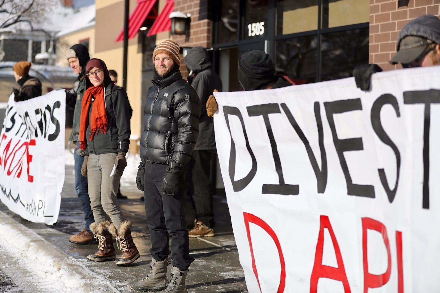 Ethan Nuss stands with about ten other protesters stand outside the new Wells Fargo Bank building on Lake Street in Minneapolis to protest Wells Fargo's involvement with the Dakota Access Pipeline.