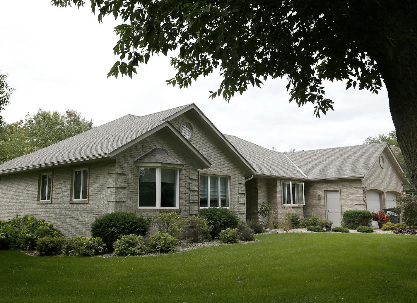 The front exterior of the 1990s brick rambler in Hastings.