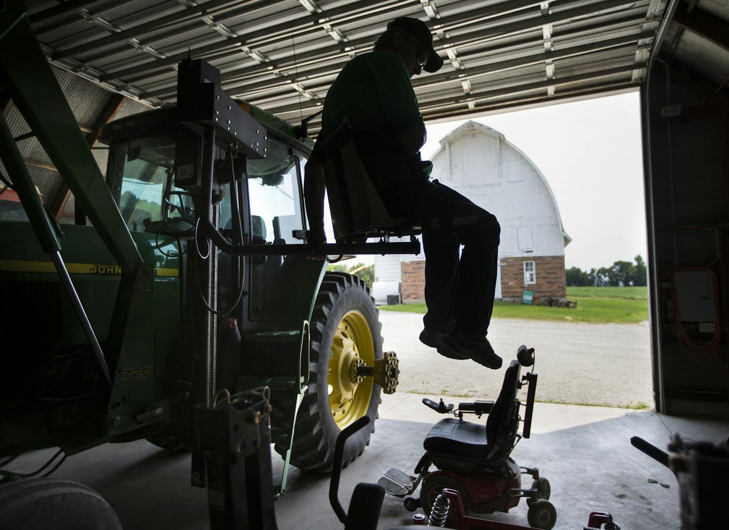 Scott Collier was paralyzed in a farm accident two years ago. He was able to get back to farming with help from the AgrAbility program by modifying and adding new farm equipment. He was photographed using a remote lift that moves him from his wheel chair to the cab of his tractor on Thursday, July 2, 2015, in Montgomery, Minn. ] RENEE JONES SCHNEIDER &#x2022; reneejones@startribune.com