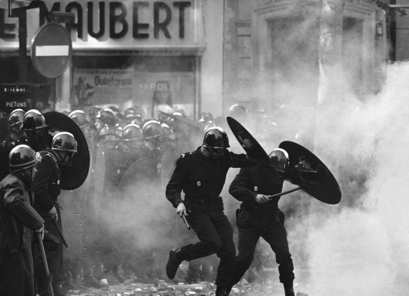 FILE - In this May 6 1968 file photo, anti-riot police charge through the streets of Paris during violent student demonstrations. Emmanuel Macron was not even born when students and workers joined forces during the May 1968 Paris uprising. Fifty years on, the French centrist president is showing no sympathy for the students who have been blocking universities for weeks in opposition to his education reforms, or the railway workers currently on strike against plans to reform the country's nationa