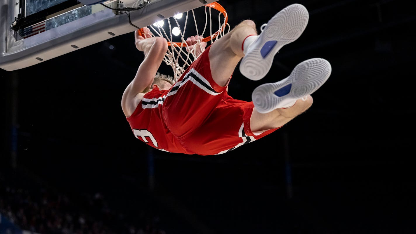 Davidson guard Michael Jones (13) holds on after a dunk against Alabama during the second half of an NCAA college basketball game, Tuesday, Dec. 21, 2021, in Birmingham, Ala. (AP Photo/Vasha Hunt)