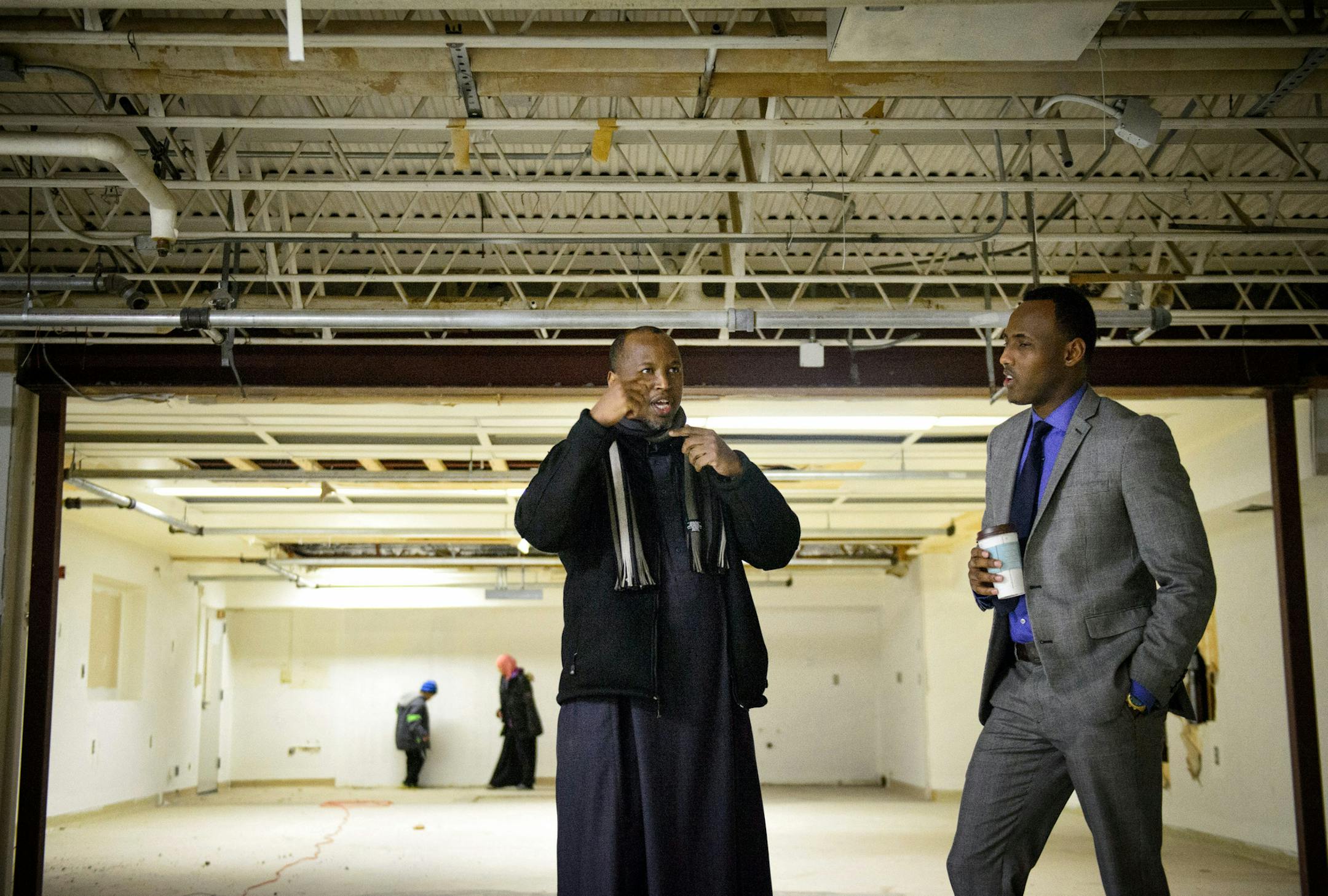 Iman Abdirahman Omar, center, and Ahmedweli Farah, right, VP of Family Care Transportation looked over the space in the basement of the St. Anthony Business Center where they hope to use as a prayer space. Many businesses in the building are Muslim owned. the Imam's children explore in the background. ] GLEN STUBBE * gstubbe@startribune.com Monday, December 22, 2014 St. Anthony City Council is expected to reverse course Tuesday night and allow a mosque in the city's business park. It took a fede