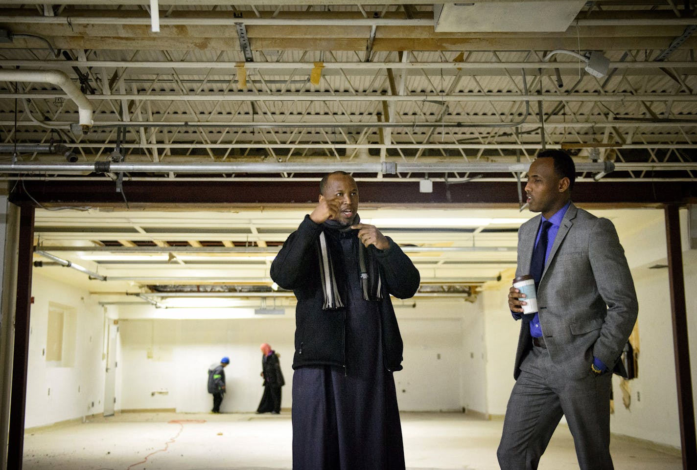 Iman Abdirahman Omar, center, and Ahmedweli Farah, right, VP of Family Care Transportation looked over the space in the basement of the St. Anthony Business Center where they hope to use as a prayer space. Many businesses in the building are Muslim owned. the Imam's children explore in the background. ] GLEN STUBBE * gstubbe@startribune.com Monday, December 22, 2014 St. Anthony City Council is expected to reverse course Tuesday night and allow a mosque in the city's business park. It took a fede