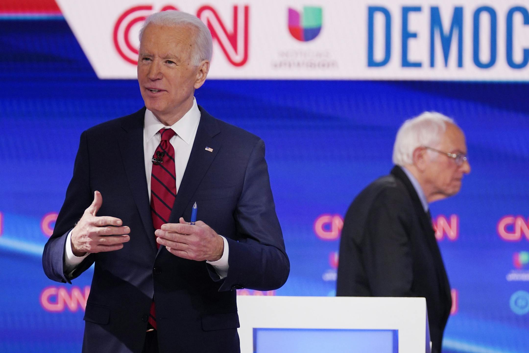 Sen. Bernie Sanders, I-Vt., right, and former Vice President Joe Biden, left, return to the stage after a commercial break in a Democratic presidential primary debate at CNN Studios, Sunday, March 15, 2020, in Washington. (AP Photo/Evan Vucci)
