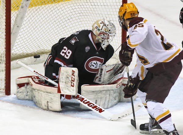 Minnesota Gophers vs. St. Cloud State University (SCSU). Minnesota's Justin Kloos (25) watched a puck slapped by teammate Nate Condon sail past SCSU g