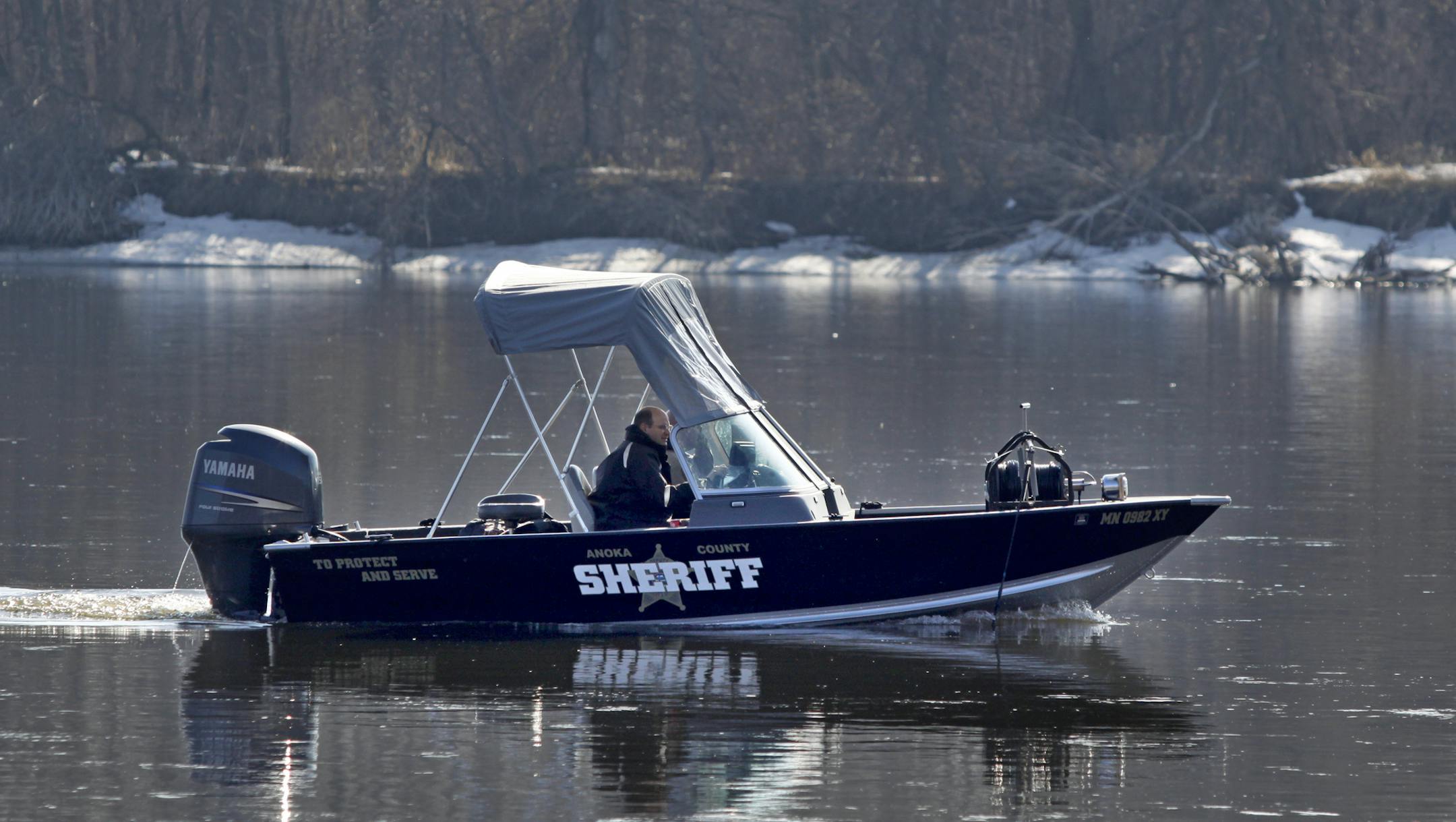 Anoka County sheriff's personnel search along the Mississippi River south of the 6100 Rivlyn Ave. location where Travis Benjamin, 39, went missing after his Hummer went into the Mississippi River early Friday.