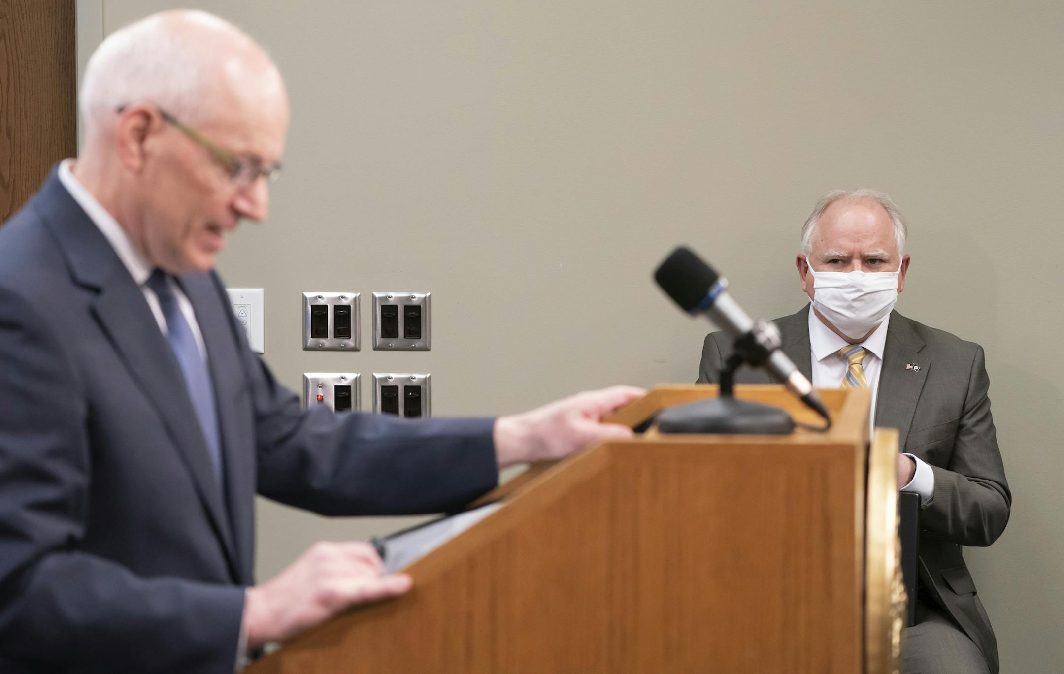 Governor Tim Walz listens as MMB Commissioner Myron Frans talks about the State of Minnesota's budget projection. The state's budget outlook crumbled from a $1.5 billion surplus to a projected $2.4 billion deficit in just two months, as the COVID-19 pandemic eats up tax revenue and Minnesota leaders accelerate spending to respond. (Glen Stubbe/Star Tribune via AP)