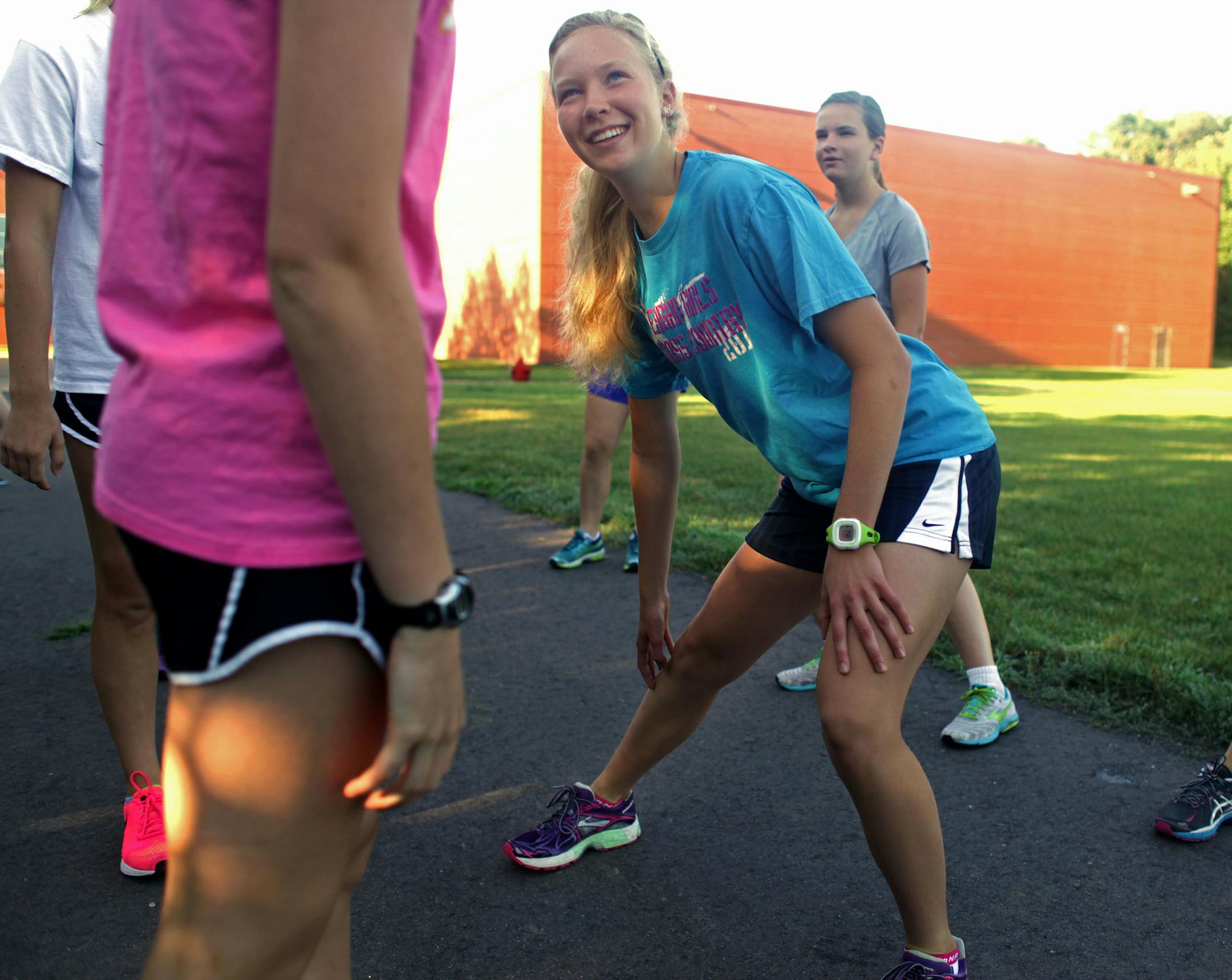 Anna Van Wyk, rising senior at Eagan High School warms up for cross country practice outside Eagan High School, early Tuesday morning. ] MONICA HERNDON monica.herndon@startribune.com Eagan, MN 08/12/14