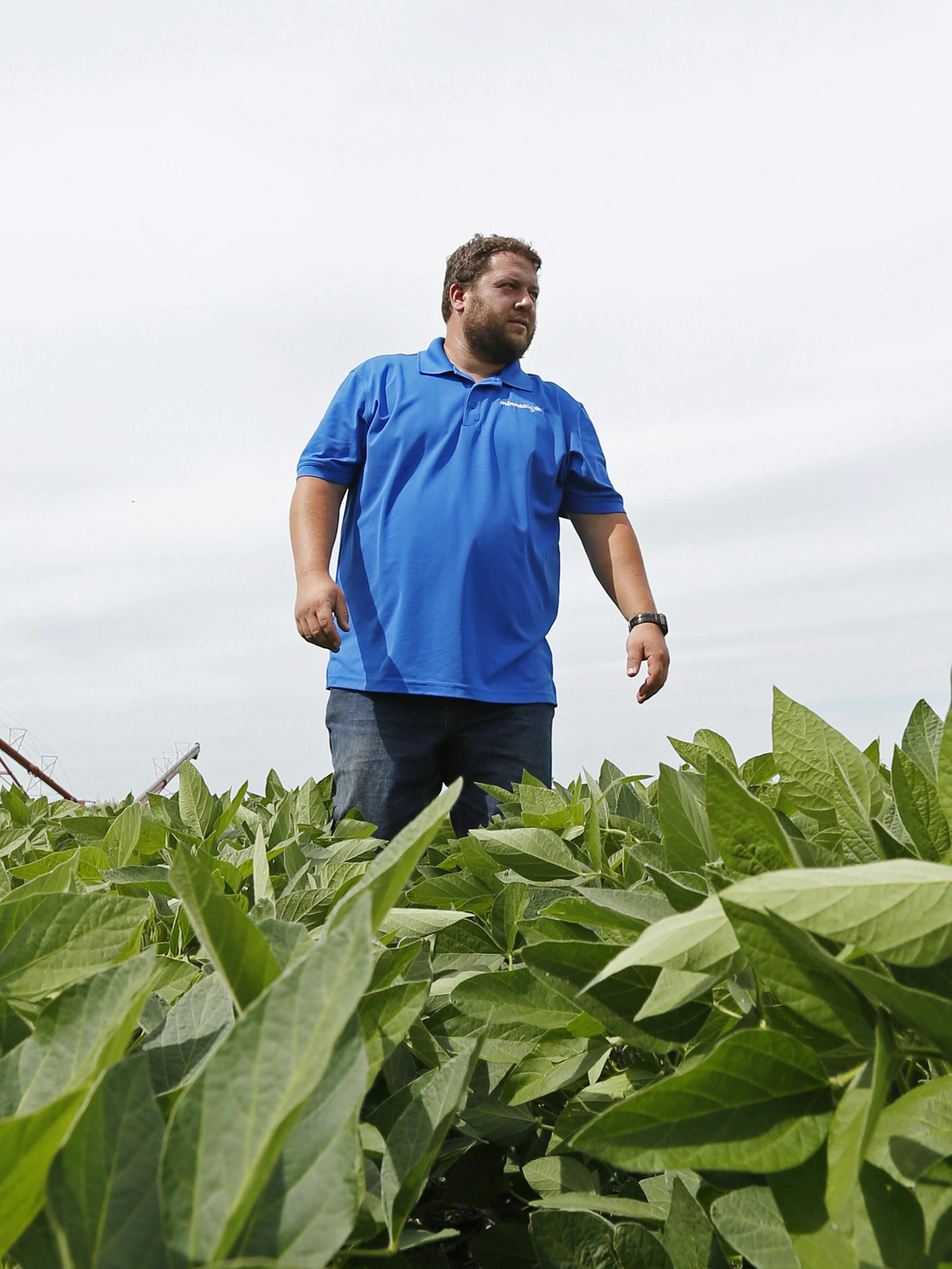 In this July 18, 2018 photo, soybean farmer Michael Petefish walks through his soybeans at his farm near Claremont in southern Minnesota. American farmers have put the brakes on unnecessary spending as the U.S.-China trade war escalates, hoping the two countries work out their differences before the full impact of China's retaliatory tariffs hits American soybean and pork producers. (AP Photo/Jim Mone) ORG XMIT: MP104