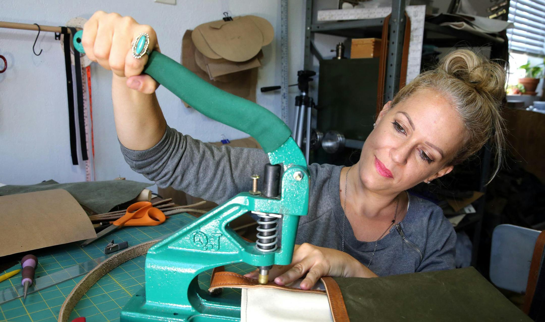 Tiffany Zadi works on a purse in her studio at home in Miami, August 30, 2017. Zadi is part of the Gig Economy, with multiple jobs. # She sells leather fashions for her one-person business called Heist. As part of that she does a lot of shows and pop-up stores and events around town as well as out of town.(CHARLES TRAINOR JR /Miami Herald/TNS)