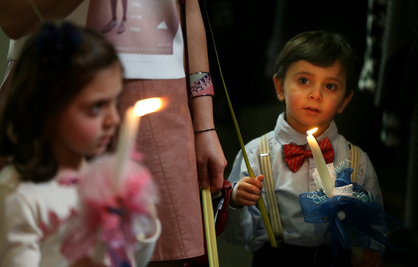 Ema Khouri 6, and her brother Anthony Khouri 3, held candles after Palm Sunday at Maron's Catholic Church March 20, 2016 in Minneapolis, MN.] Palm Sunday at St. Maron's Catholic Church in NE Minneapolis, home to many Middle Eastern families, including Syrians with loved ones back home. Jerry Holt/Jerry.Holt@Startribune.com