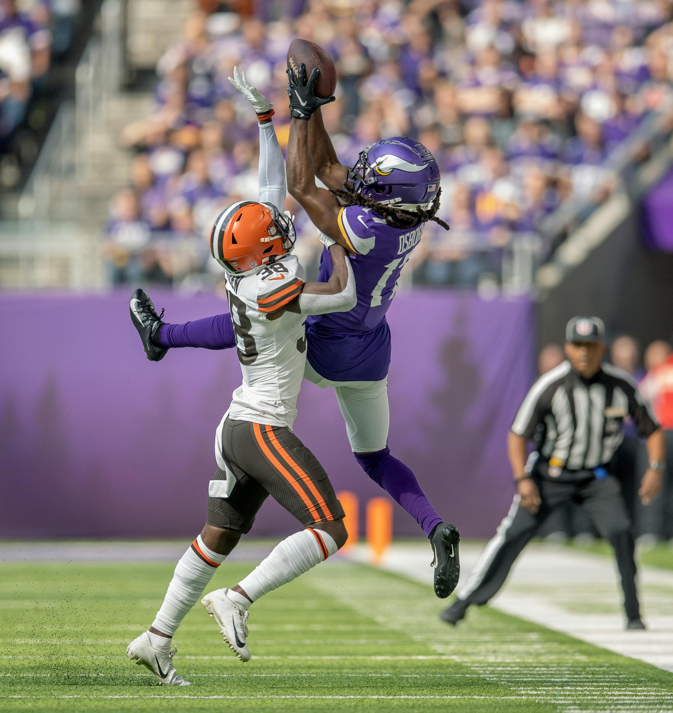 Vikings wide receiver K.J. Osborn (17) made a grab  despite defensive pressure from Browns A.J. Green in the first quarter.