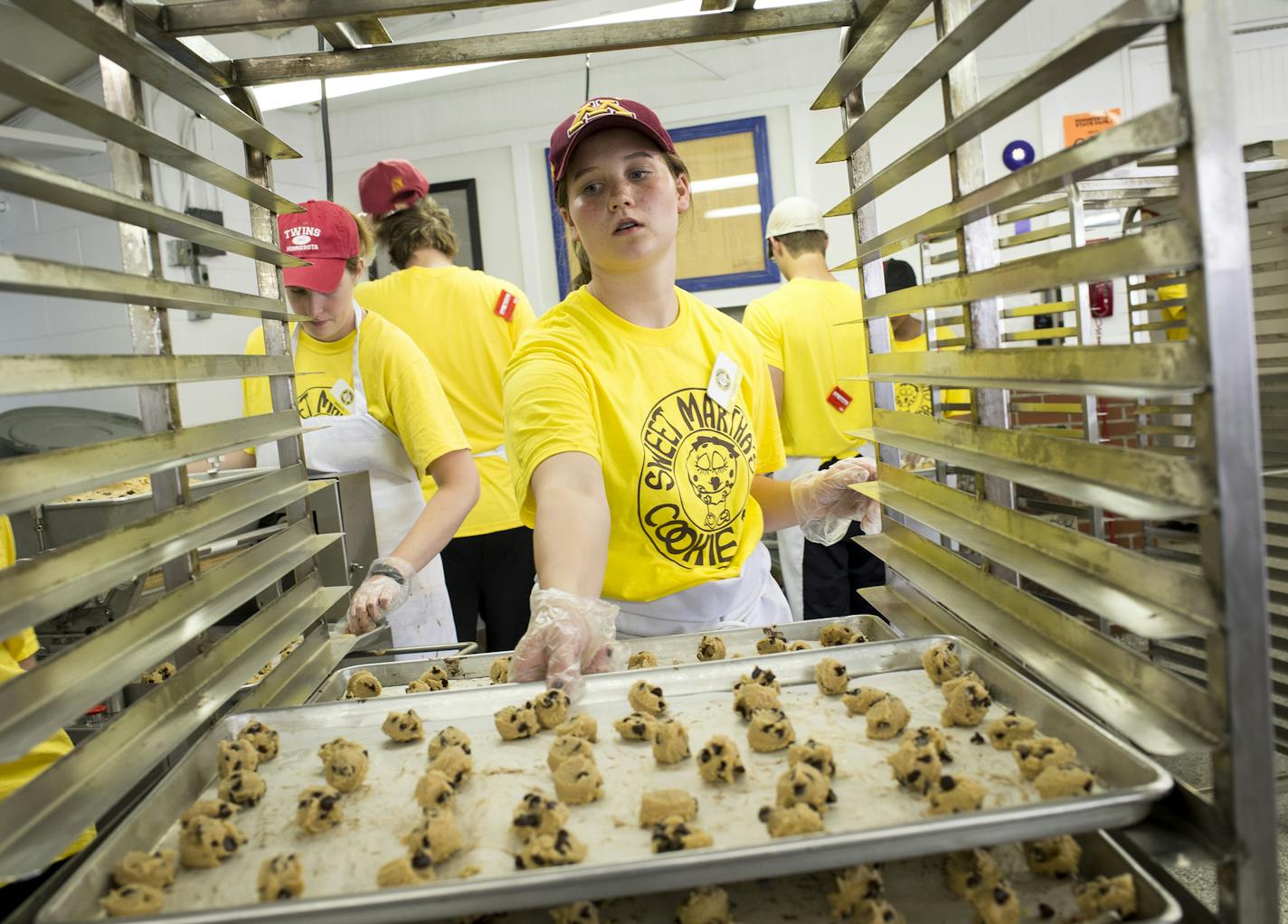 Lucie Hoeschen placed a baking sheet with dollops of cookie dough onto a cart before the cart was moved to the oven. The ovens can handle 24,000 cookies every 12 minutes.