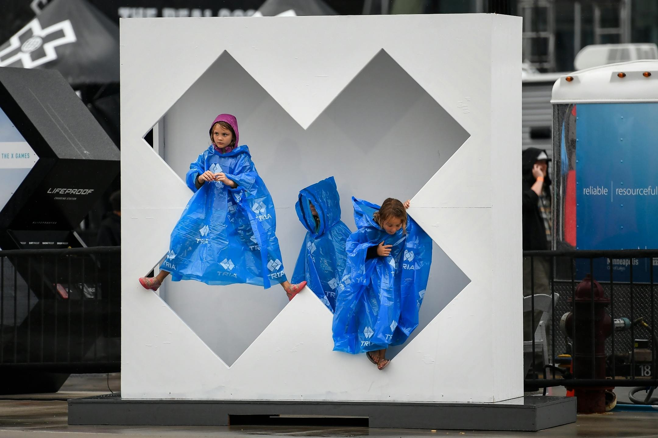 From left, sisters Olivia, 8, Madison, 6, and Evalyn Butcher, 5, of Minneapolis, stood inside a to-be pained X Games sculpture for a photo Thursday as rain fell outside US Bank Stadium.