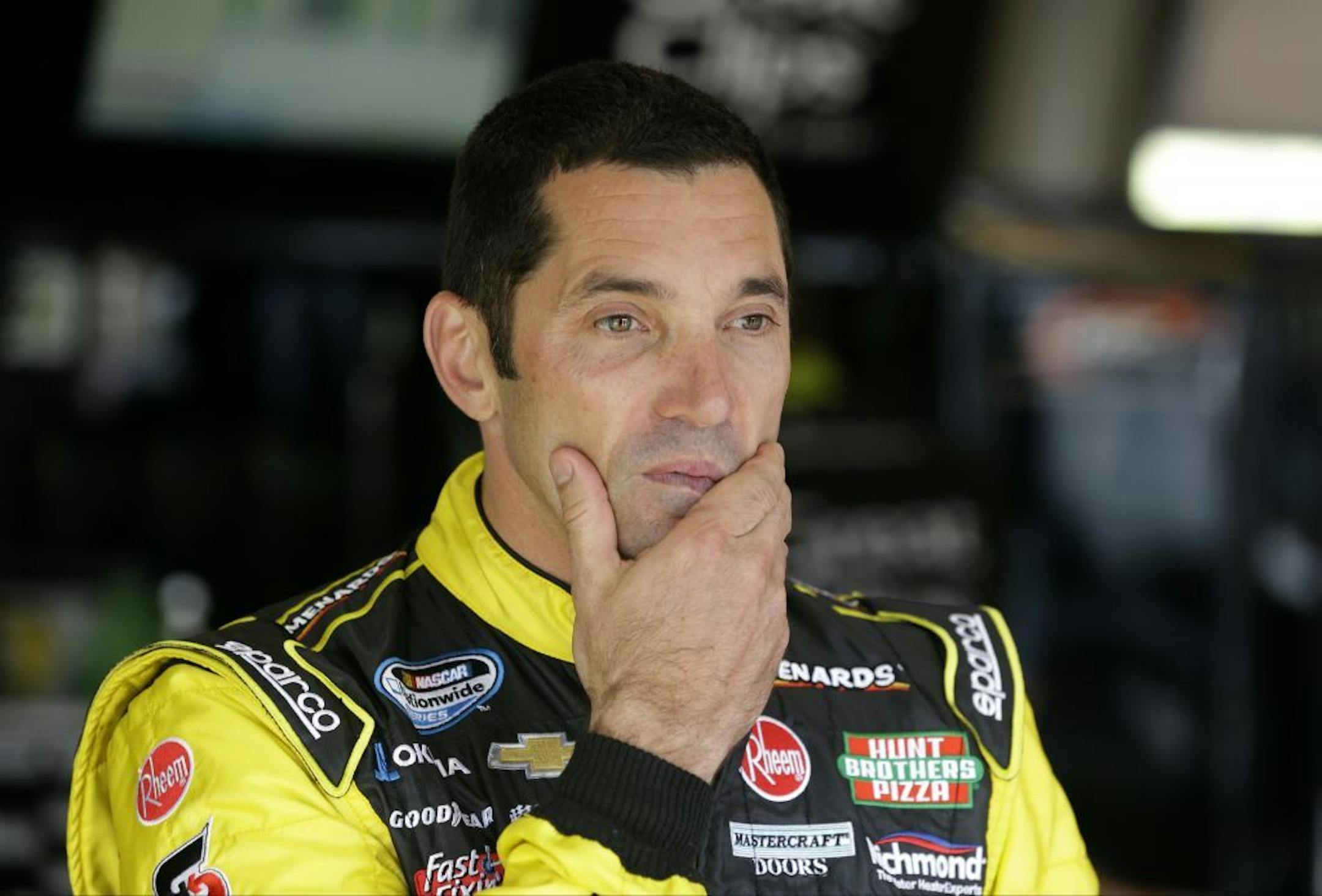 FILE - In this June 7, 2013, file photo, Max Papis stands in the garage before driving practice laps in preparation for the NASCAR Nationwide series auto race at Iowa Speedway in Newton, Iowa. Papis got the call from Stewart-Haas Racing and will replace Tony Stewart, the three-time NASCAR champion, this weekend at Watkins Glen International, where Papis will make his first Sprint Cup Series start since 2010. But it will be Papis' 13th career start at Watkins Glen.