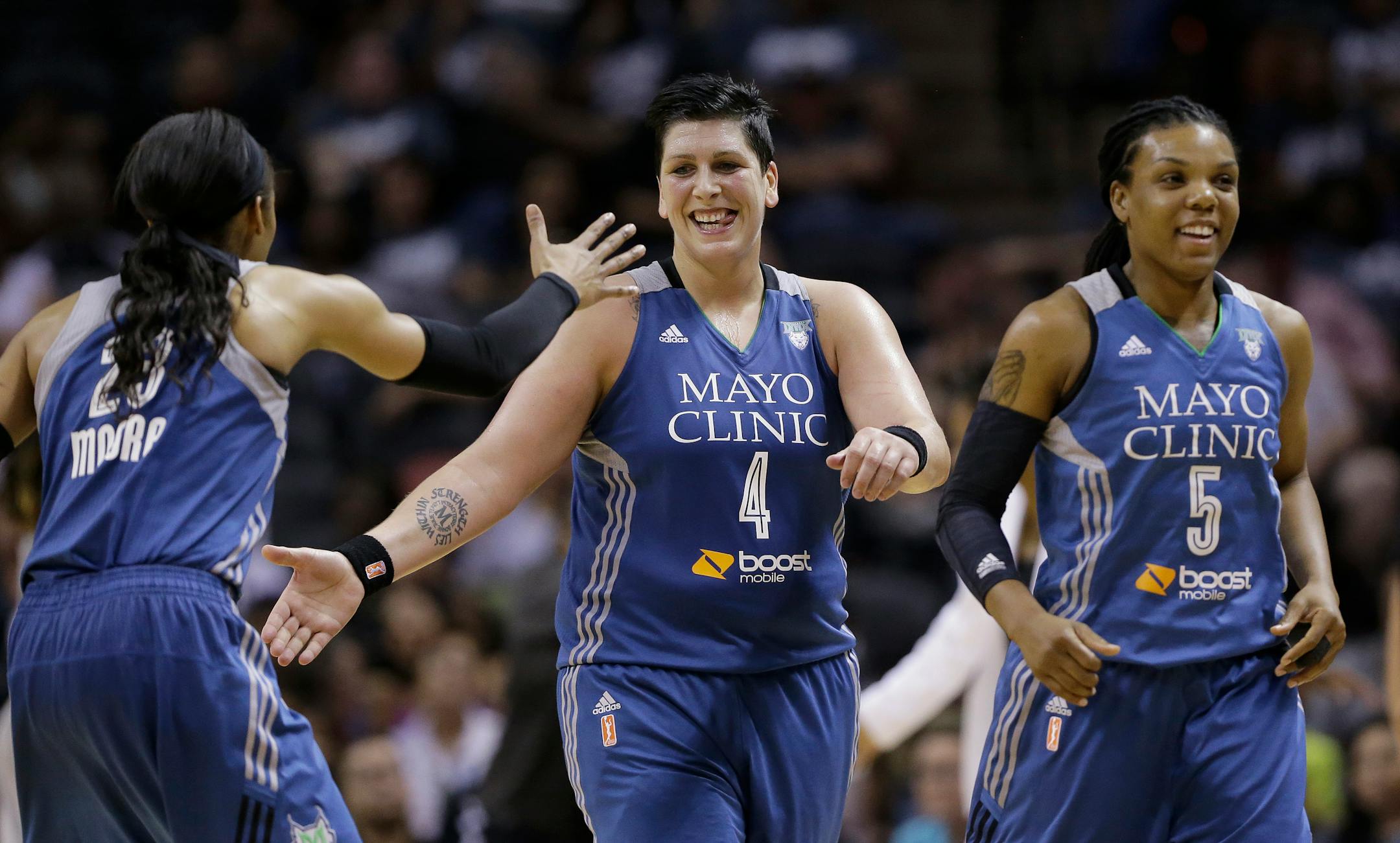 Minnesota Lynx's Janel McCarville (4) celebrates with teammates Maya Moore (23) and Tan White (5) during the second half in Game 2 of a WNBA basketball Western Conference semifinal against the San Antonio Stars, Saturday, Aug. 23, 2014, in San Antonio. Minnesota won 94-89. (AP Photo/Eric Gay)