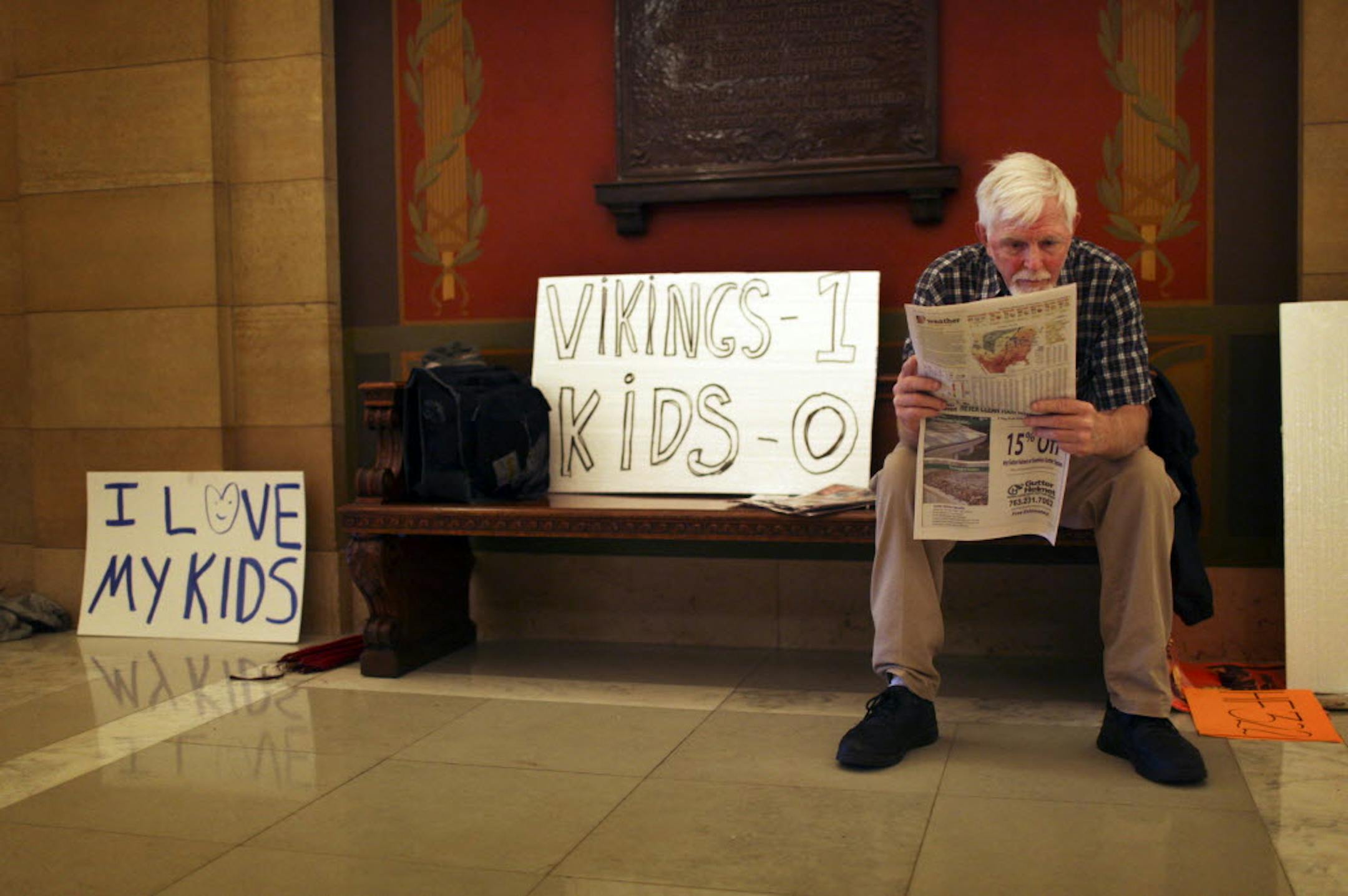 Fathers-rights activist John Hurd of North Mankato read a newspaper while he and other activists gathered outside Gov. Mark Dayton's office Thursday, while waiting to see if Dayton vetoed HF 322. Hurd, who has raised two children, said, "shared parenting is much superior." Dayton did not sign the bill.