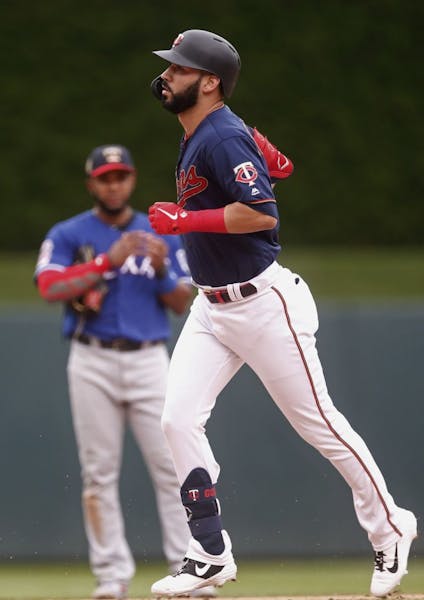 Minnesota Twins' Marwin Gonzalez, foreground, rounds the bases on a solo home run off Texas Rangers pitcher Shawn Kelley in the eighth inning of a bas