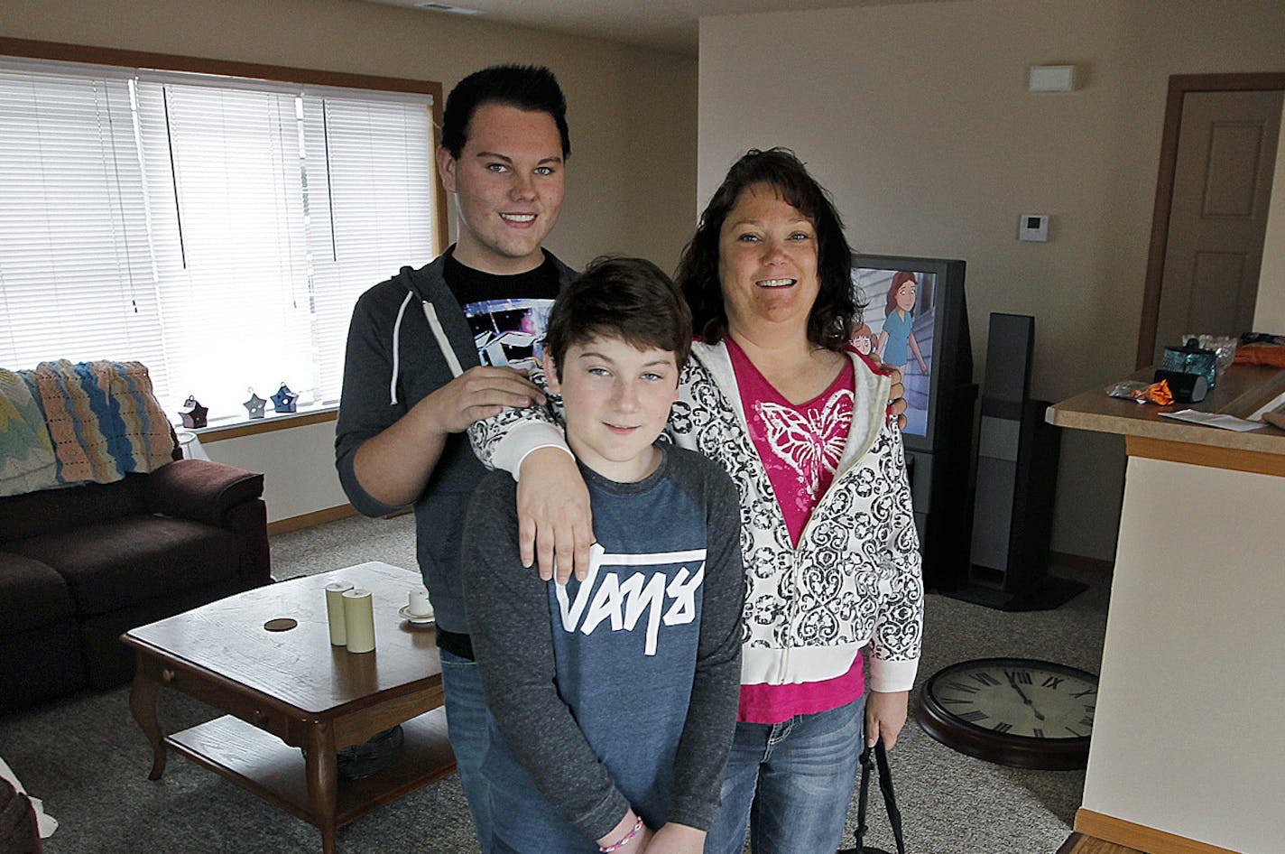 Kris Thuhl and her sons Paul, 16, left, and Jack, 13, center, and their dog "Max" are still getting adjusted to the new home they just moved into, Thursday, November 14, 2013 in Ramsey, MN. UnitedHealth is investing $50 million in Minnesota to build affordable housing units. Their home, is in the Seasons Townhomes, a 50-unit complex in Ramsey that is part of a $100 million nationwide investment. (ELIZABETH FLORES/STAR TRIBUNE) ELIZABETH FLORES &#x2022; eflores@startribune.com