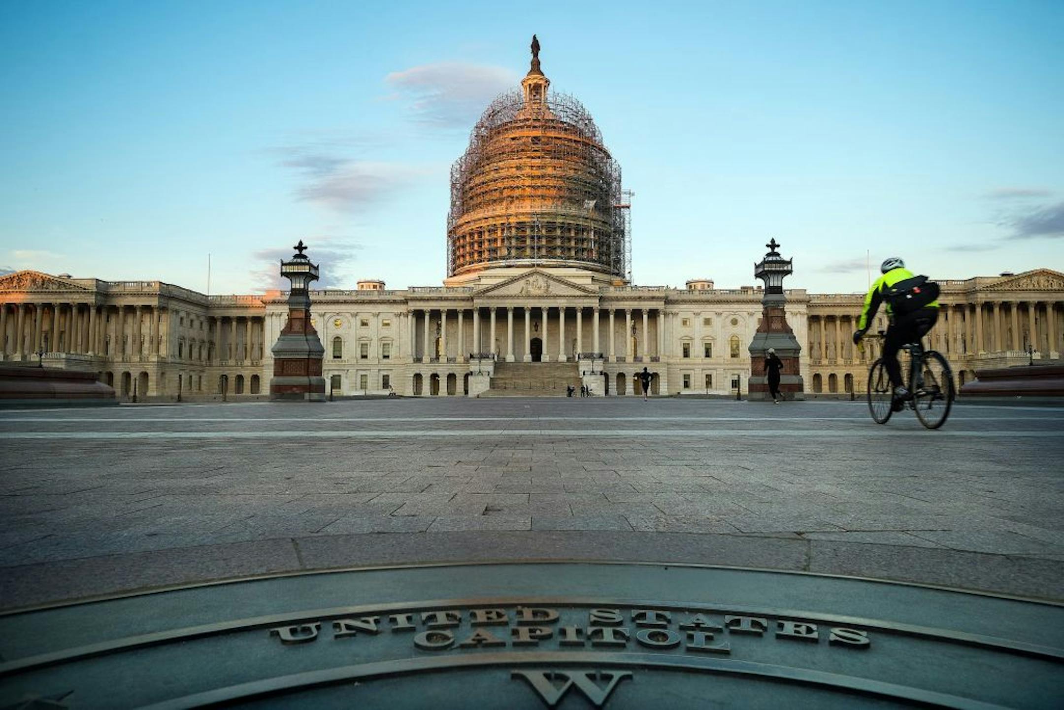 A cyclist rides across the front plaza of the US Capitol early Tuesday morning Nov. 4, 2014 in Washington. Voters will device the make-up of the new Congress as they head to the poles today for mid-term elections. (AP Photo/J. David Ake) ORG XMIT: MIN2015010218355986
