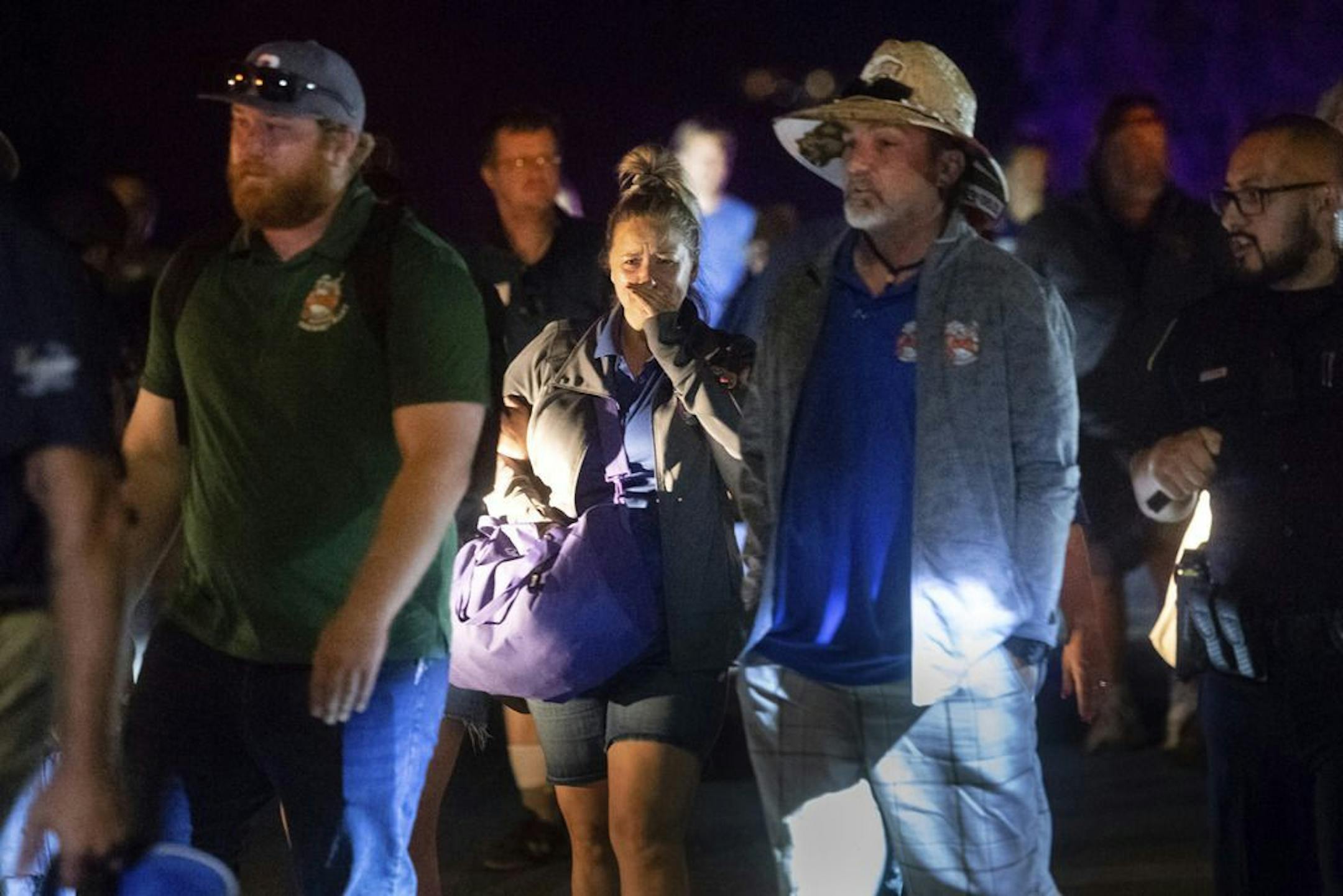 Police officers escort people from Christmas Hill Park following a deadly shooting during the Gilroy Garlic Festival, in Gilroy, Calif., on Sunday, July 28, 2019.