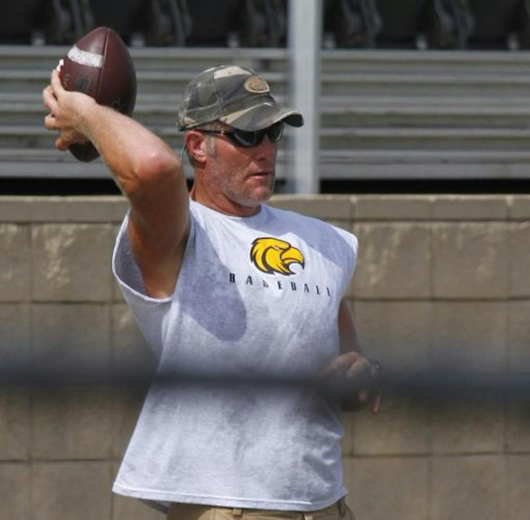 Minnesota Viking quarterback Brett Favre throws a few passes to members of the Oak Grove High School football team in Hattiesburg, Miss., Monday, July 12, 2010. Favre has been a fixture at the school for several summers, taking his turn at quarterback and passing to the high school players during their voluntary summer practice.