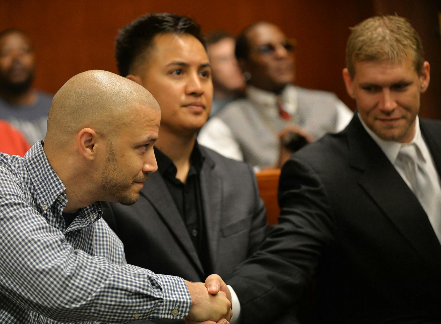 From left, all Veteran graduates, Charles King shook hands over Tar Po or "Tim" with Chris Hvinden in Ramsey County District Court during the The Veterans graduation ceremony in St. Paul, Minn., on Thursday July 9, 2015. The Ramsey County Veterans Treatment Court held a graduation ceremony for four veterans. ] RACHEL WOOLF &#x2211; rachel.woolf@startribune.com