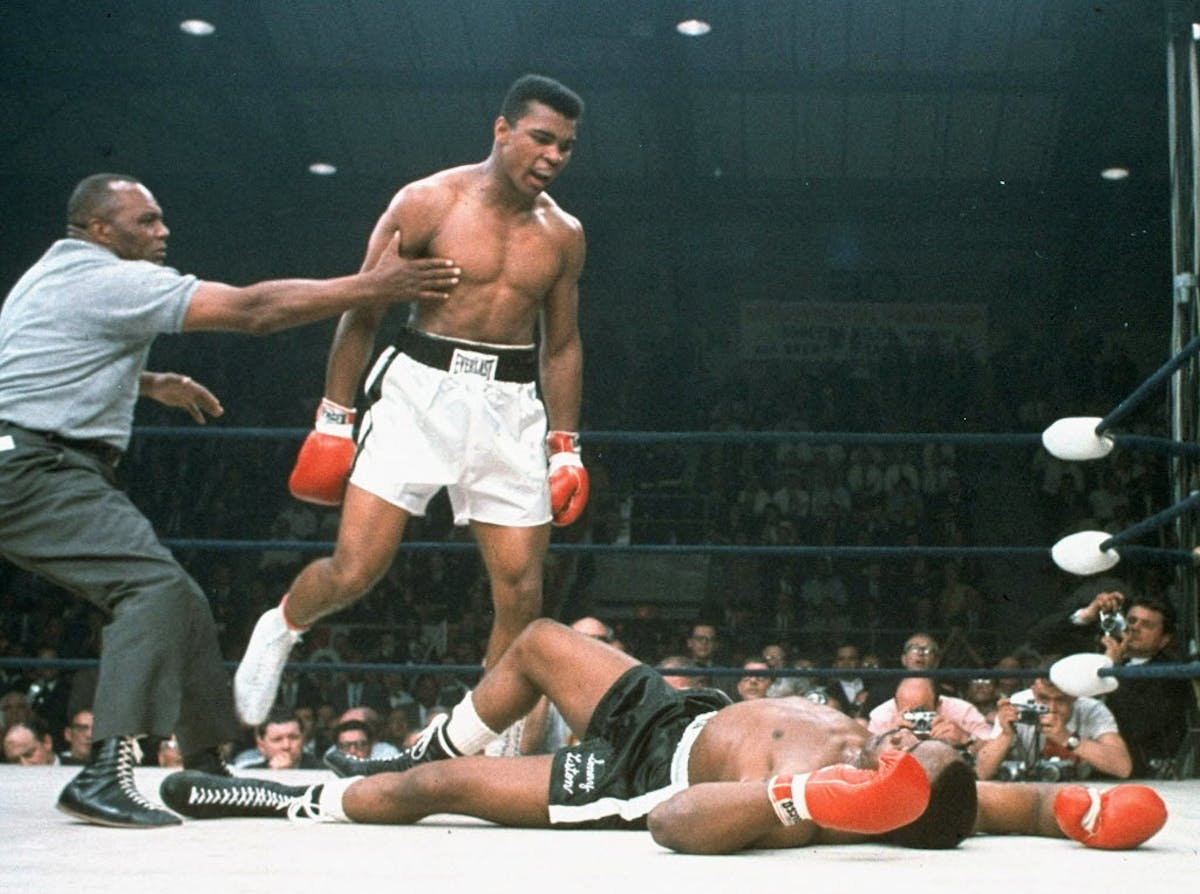 FILE - In this May 25, 1965, file photo, heavyweight champion Muhammad Ali is held back by referee Joe Walcott, left, after Ali knocked out challenger