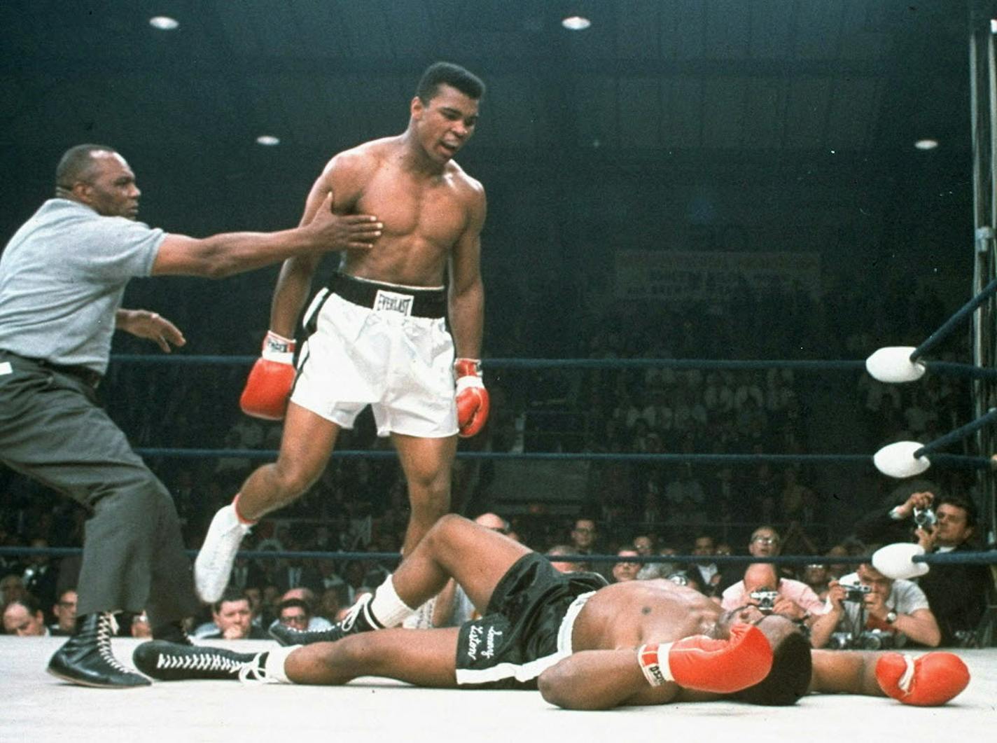 FILE - In this May 25, 1965, file photo, heavyweight champion Muhammad Ali is held back by referee Joe Walcott, left, after Ali knocked out challenger Sonny Liston in the first round of their title fight in Lewiston, Maine. Ali, the magnificent heavyweight champion whose fast fists and irrepressible personality transcended sports and captivated the world, has died according to a statement release