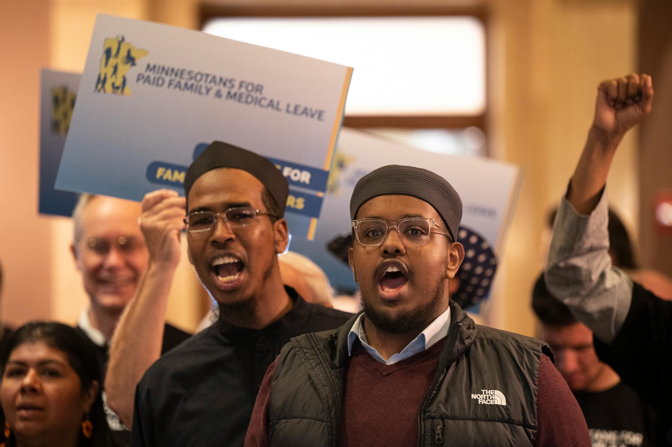 Khalid Omar, right of center, with ISAIAH and Faith in Minnesota, leads a chant in Somali of "Today, today, today is a big day," with paid family leave advocates at the Minnesota State Capitol Monday.